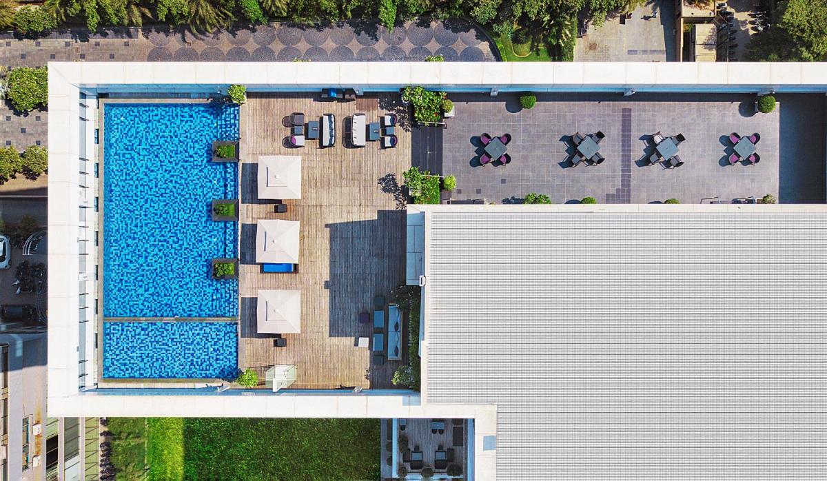 an overhead view of a swimming pool next to a building at Renaissance Ahmedabad Hotel in Ahmedabad