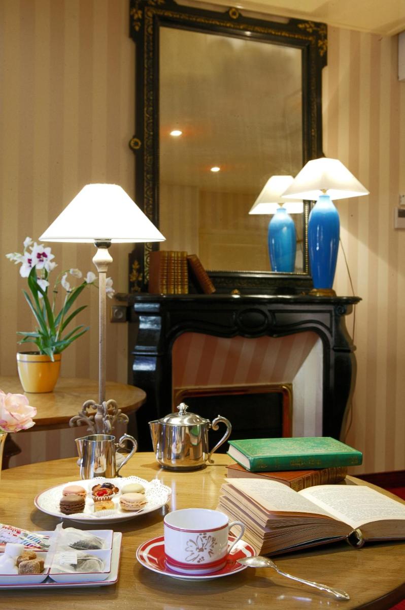 - une table avec un livre et un miroir dans l'établissement Clos La Boëtie & Spa, à Sarlat-la-Canéda