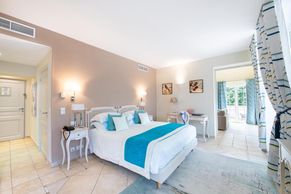 - une chambre avec un grand lit blanc dans l'établissement Hôtel Golf & Spa Château de la Bégude The Originals Collection, à Valbonne