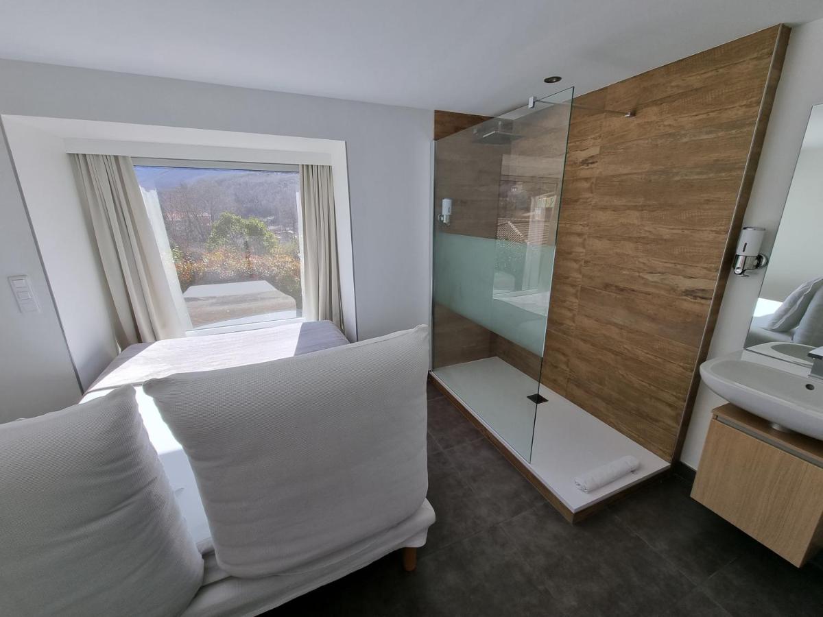 une salle de bain avec un lit, un lavabo et un miroir dans l'établissement Artemisia Boutique Hotel, à Bastelica