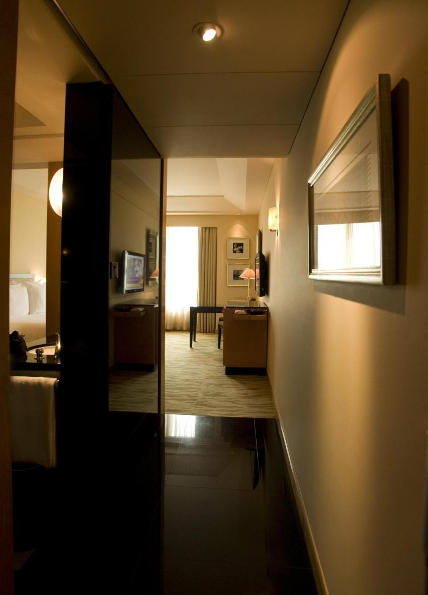 a hallway of a hotel room with a mirror at The Grand New Delhi in New Delhi a hallway of a hotel room with a mirror at The Grand New Delhi in New Delhi