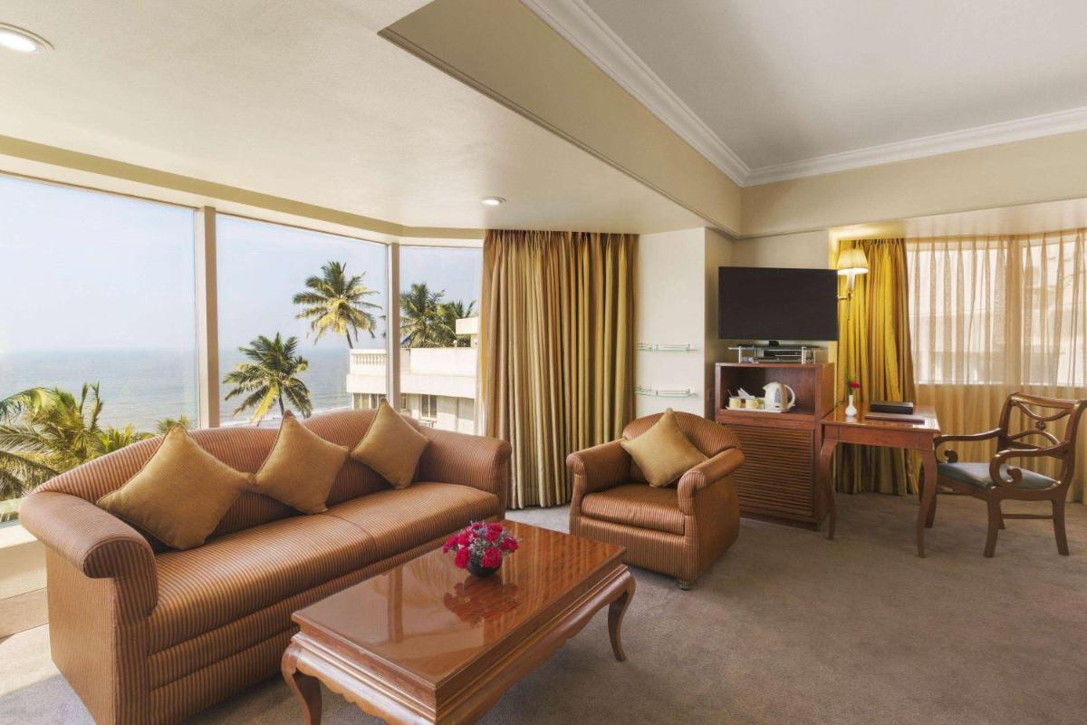 a living room with a couch and a table at Ramada Plaza By Wyndham Palm Grove in Mumbai