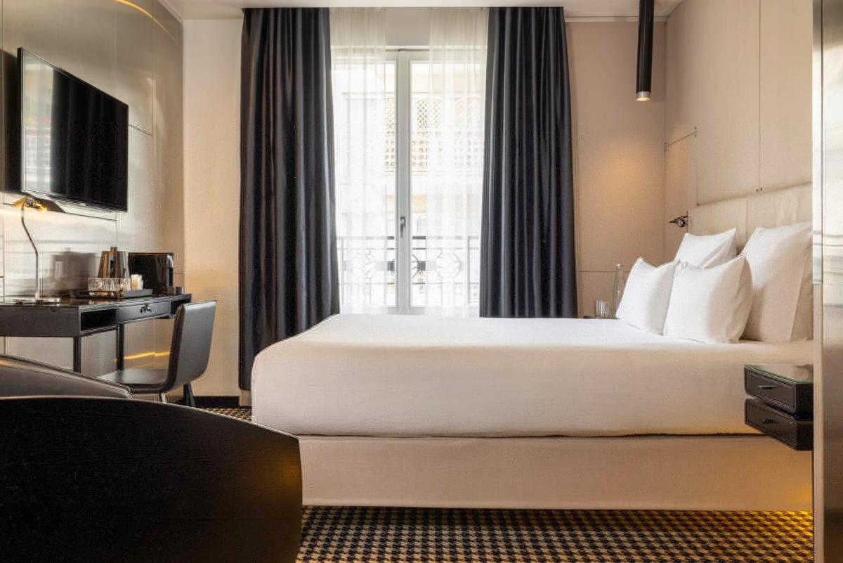 une chambre d'hôtel avec un grand lit et une fenêtre dans l'établissement Hôtel Félicien & Spa, à Paris