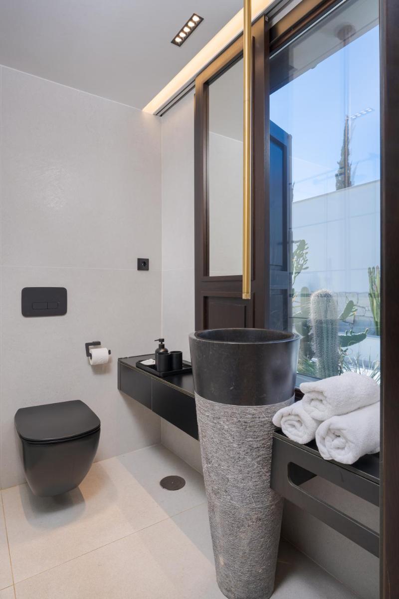 Un baño con inodoro, lavabo y ventana. en Fahana - Gay Men Only, en Playa del Inglés