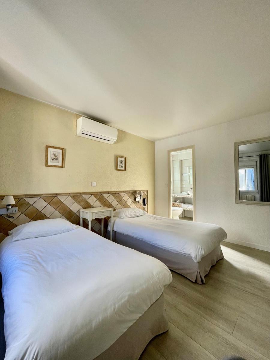 une chambre d'hôtel avec deux lits et une fenêtre dans l'établissement Franceschini, à Ghisonaccia
