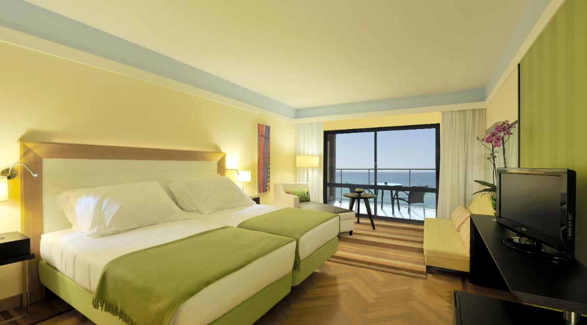 um quarto de hotel com uma cama e uma televisão em Pestana Promenade Ocean Resort Hotel no Funchal