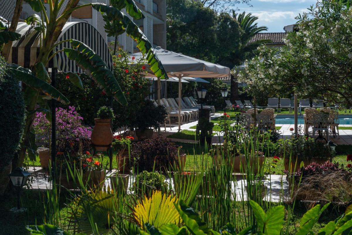 Un jardín con flores y plantas frente a un edificio. en Hotel Araxa - Adults Only, en Palma de Mallorca