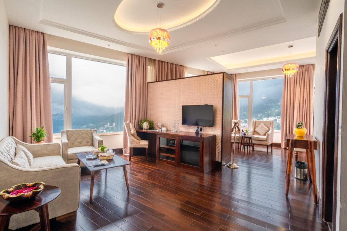 a living room with a couch and a television at The Orchid Shimla in Shimla