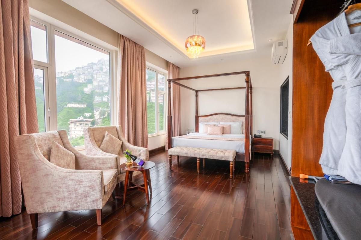 a bedroom with a bed and two chairs at The Orchid Shimla in Shimla