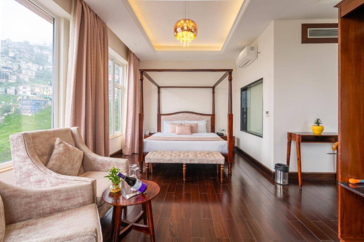a hotel room with a bed and a couch at The Orchid Shimla in Shimla