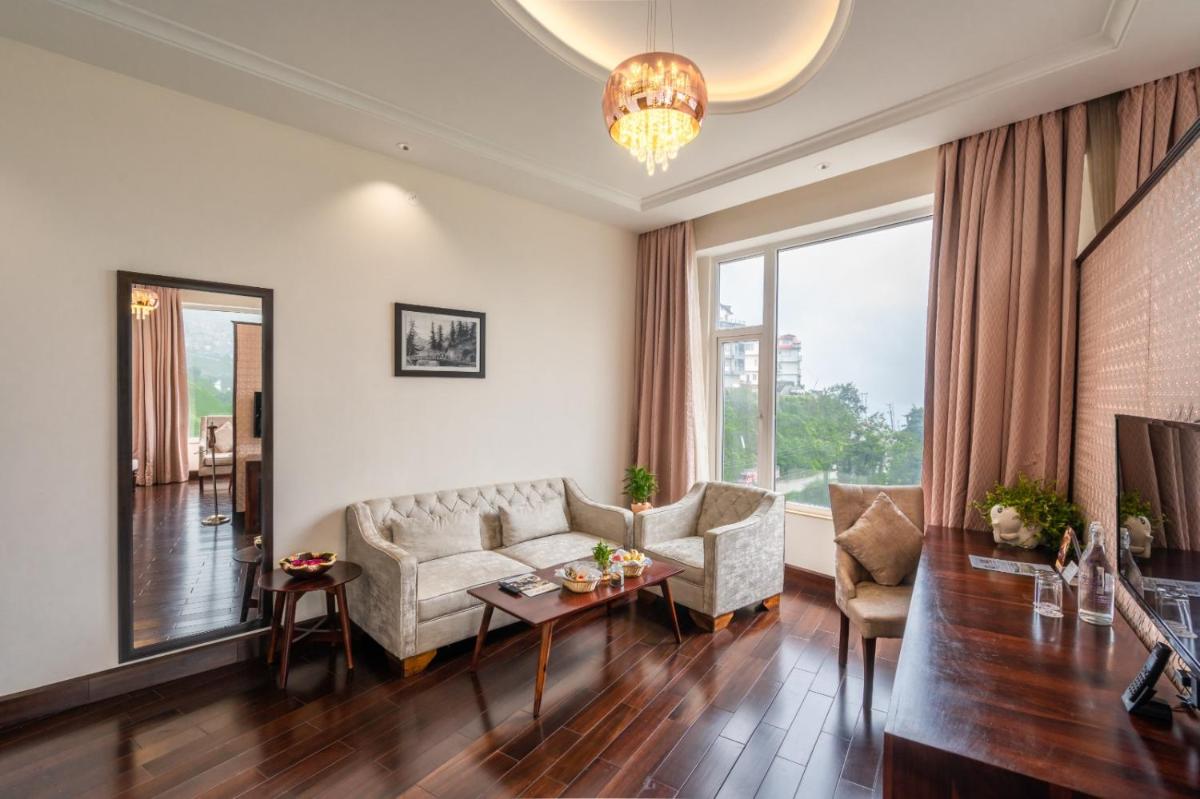 a living room with a couch and a table at The Orchid Shimla in Shimla