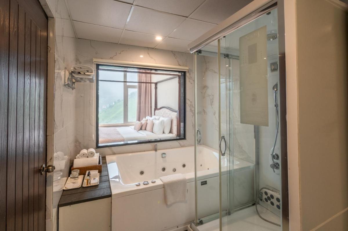 a bathroom with a tub and a sink and a shower at The Orchid Shimla in Shimla