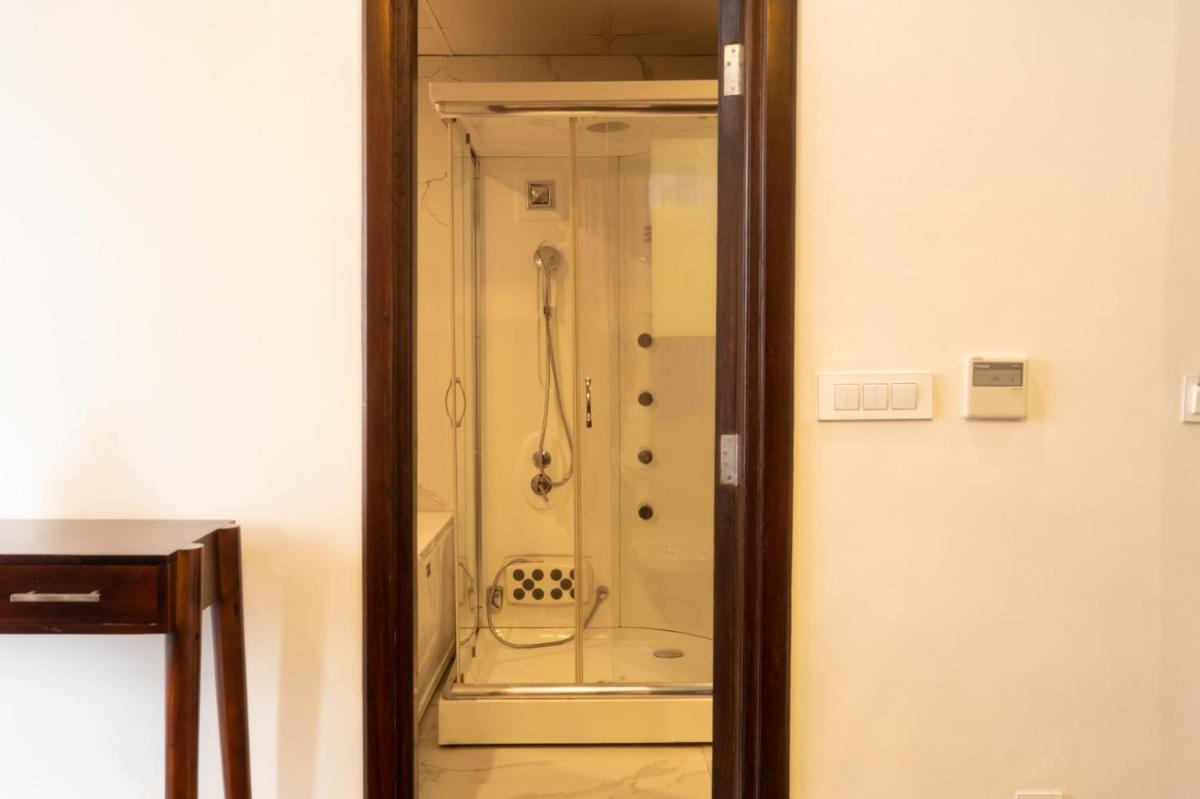a shower in a bathroom with a glass door at The Orchid Shimla in Shimla