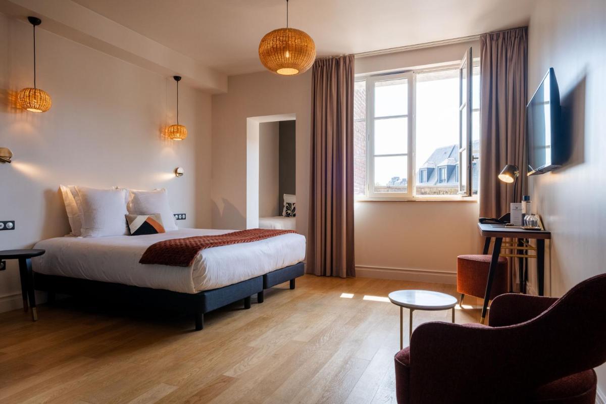 une chambre d'hôtel avec un lit et une télévision dans l'établissement L'INVITATION AU VOYAGE - Hôtel & Spa, à Honfleur