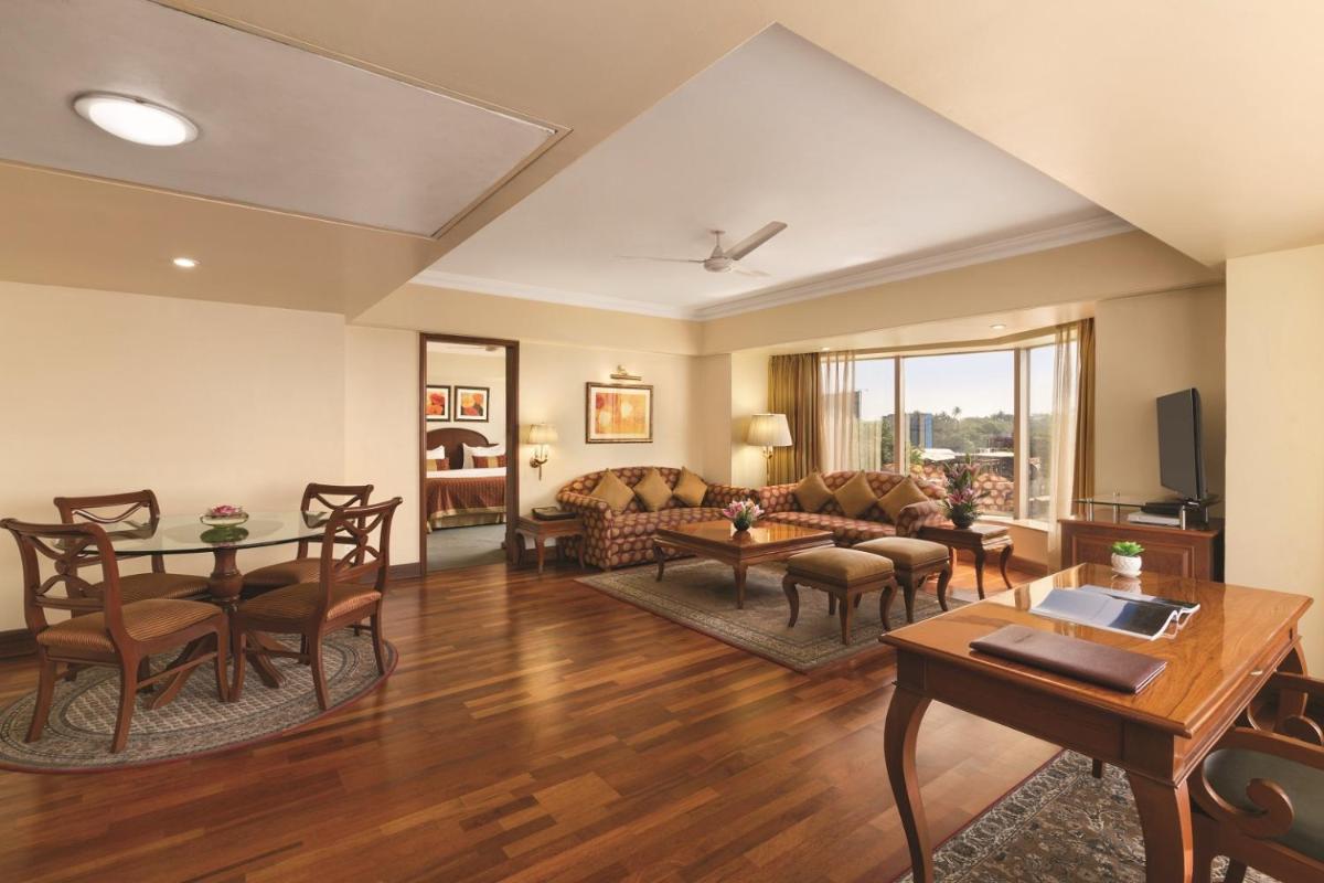 a living room with a couch and a table at Ramada Plaza By Wyndham Palm Grove in Mumbai