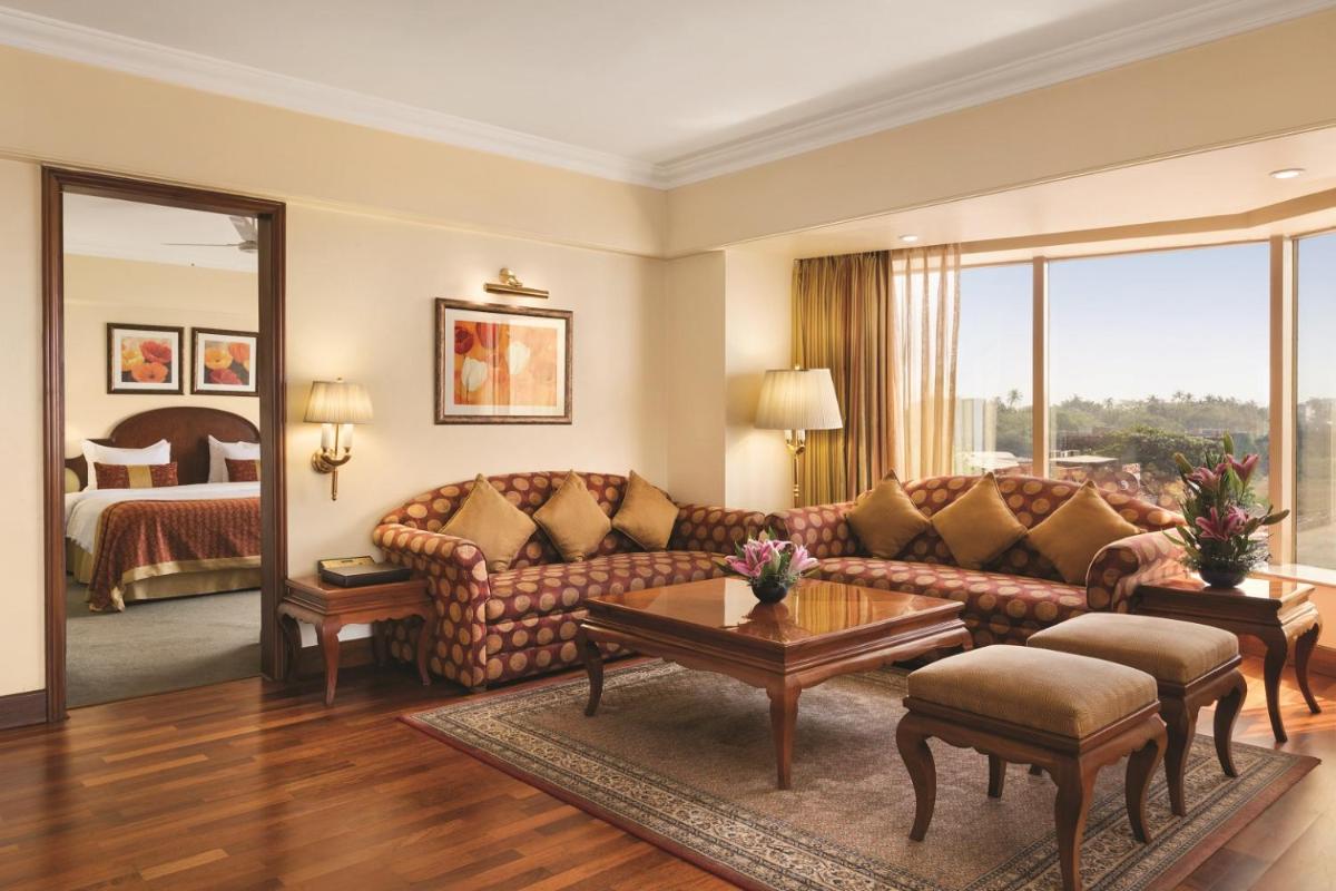 a living room with a couch and a bed at Ramada Plaza By Wyndham Palm Grove in Mumbai