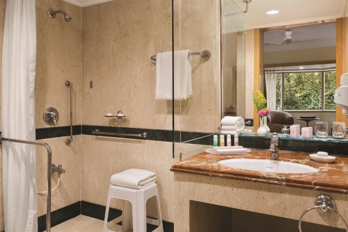 a bathroom with a sink and a shower at Ramada Plaza By Wyndham Palm Grove in Mumbai