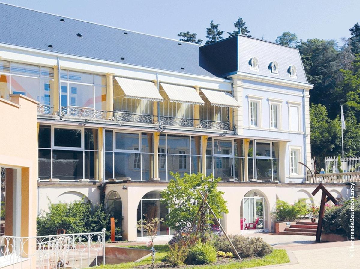un grand bâtiment blanc avec beaucoup de fenêtres dans l'établissement Grand Hôtel de Bourbon-Lancy - Spa et Restaurant - Logis, à Bourbon-Lancy