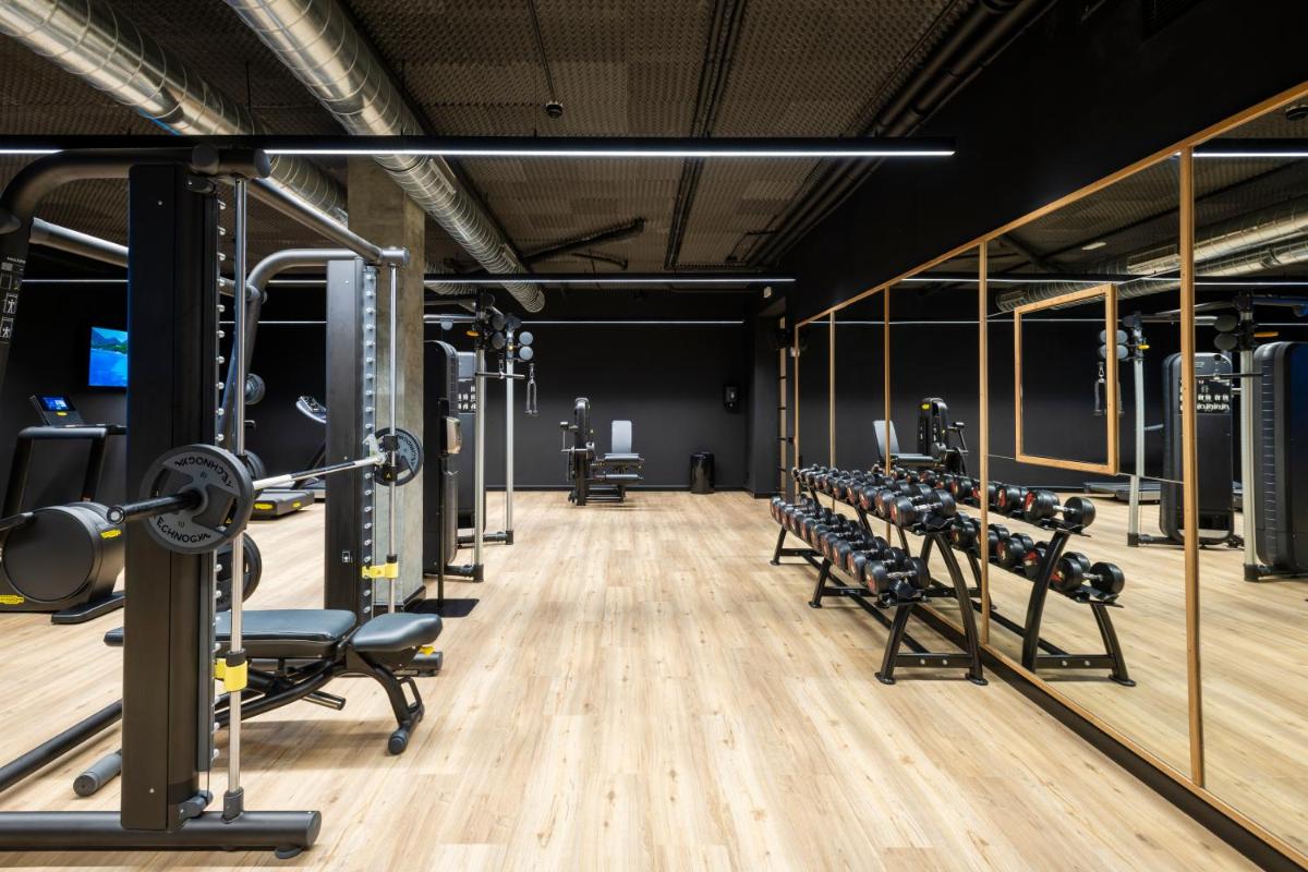 un gimnasio con filas de cintas de correr y mancuernas en Inturotel Sa Marina, en Cala d´Or