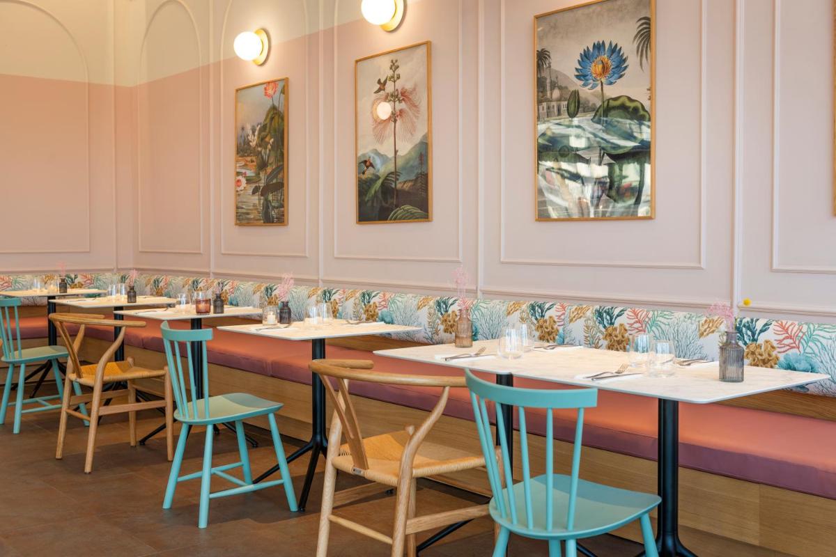 una fila de mesas en un restaurante con sillas azules en Inturotel Sa Marina, en Cala d´Or