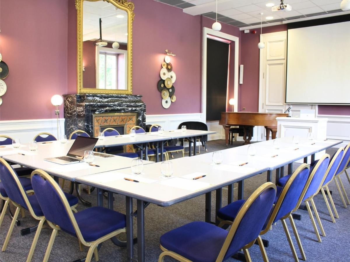 une salle de conférence avec une grande table et des chaises dans l'établissement Grand Hôtel de Bourbon-Lancy - Spa et Restaurant - Logis, à Bourbon-Lancy 80 autres photos