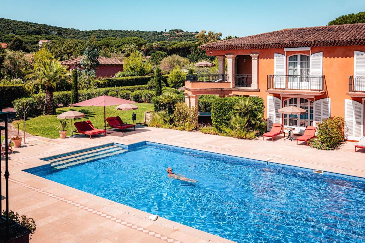 une personne se baignant dans une piscine en face d'une maison dans l'établissement Domaine de l'Astragale, à Saint-Tropez