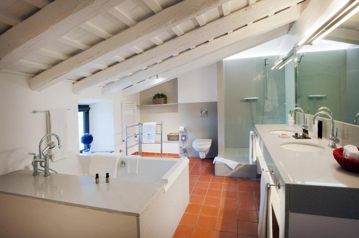 Un baño con dos lavabos y una ducha y un inodoro. en Mas Falgarona Hotel Boutique & SPA, en Avinyonet de Puigventós Un baño con dos lavabos y una ducha y un inodoro. en Mas Falgarona Hotel Boutique & SPA, en Avinyonet de Puigventós
