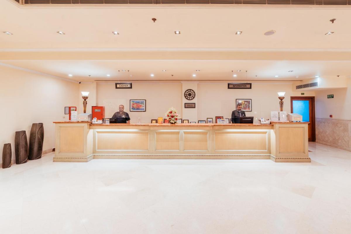 two people sitting at the reception desk of a hospital at The Piccadily in Lucknow