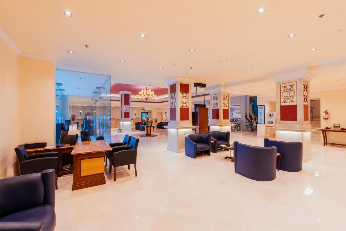 a lobby with chairs and tables in a building at The Piccadily in Lucknow