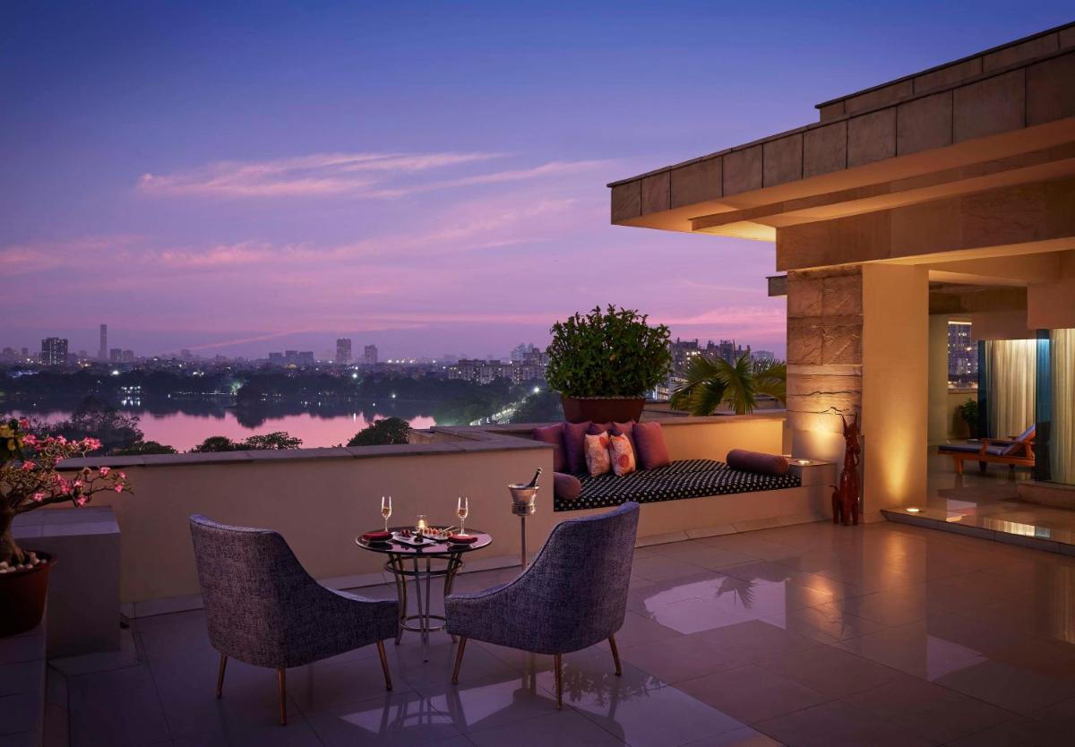 a patio with a table and chairs on a balcony at Hyatt Regency Kolkata in Kolkata a patio with a table and chairs on a balcony at Hyatt Regency Kolkata in Kolkata