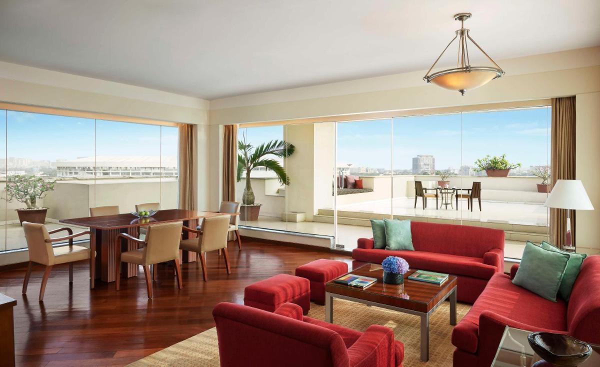 a living room with red furniture and a dining room at Hyatt Regency Kolkata in Kolkata a living room with red furniture and a dining room at Hyatt Regency Kolkata in Kolkata