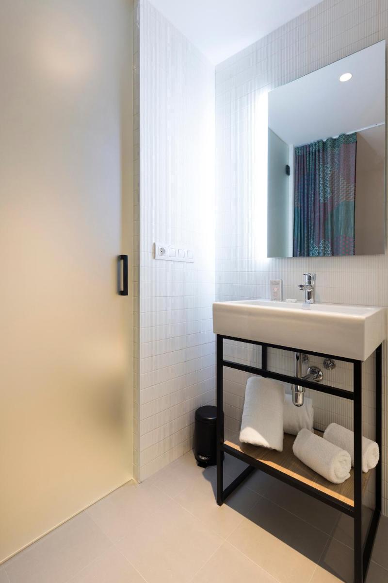 un baño con lavabo y espejo en Axel Hotel Bilbao - Adults Only, en Bilbao