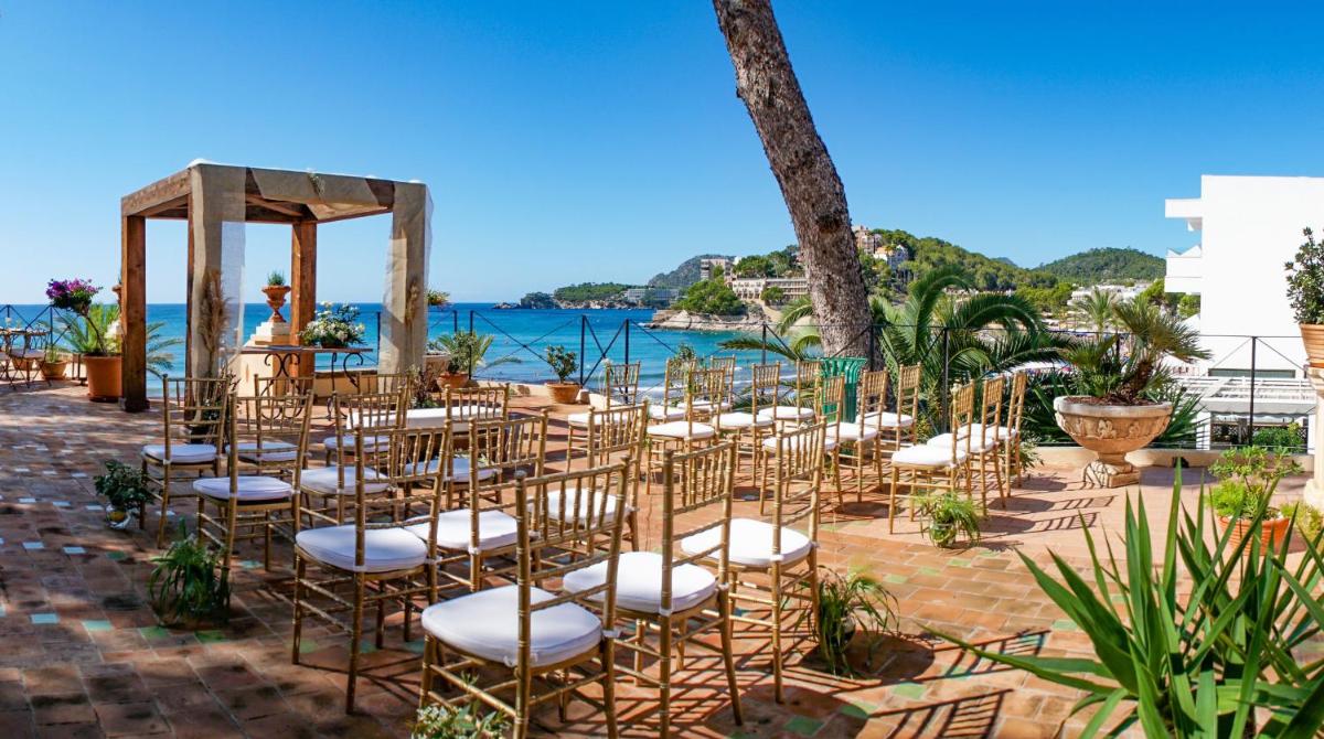 una boda al aire libre con sillas y cenador en Secrets Mallorca Villamil Resort & Spa - Adults Only (+18), en Paguera
