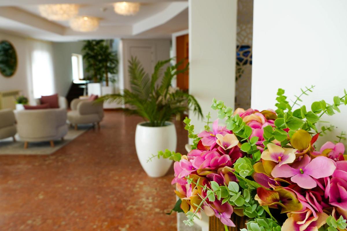 um lobby com dois vasos brancos com flores em Miramar Hotel Spa & Apartments na Nazaré
