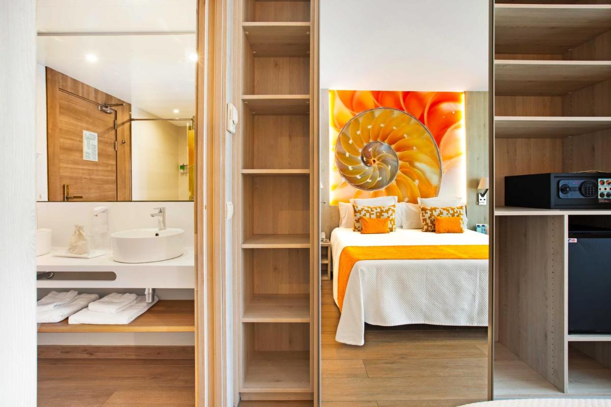 Un baño con una cama y un lavabo en una habitación. en Sumus Hotel Stella and Spa 4S Adults Recommended, en Pineda de Mar Un baño con una cama y un lavabo en una habitación. en Sumus Hotel Stella and Spa 4S Adults Recommended, en Pineda de Mar