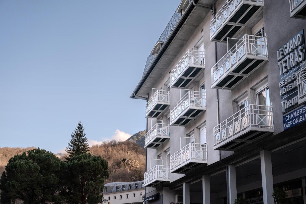 un bâtiment blanc avec des balcons sur le côté dans l'établissement Résidence Le Grand Tétras- SPA THERMAL INCLUS, à Ax-les-Thermes