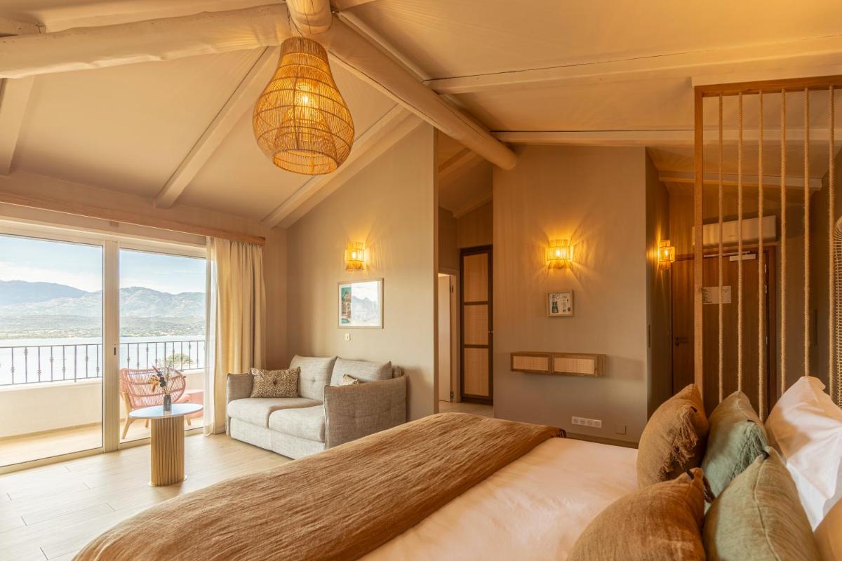 une chambre avec un grand lit et un salon dans l'établissement Hotel Riva Beach, à Porto-Vecchio