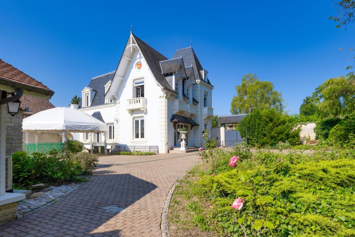 une grande maison blanche avec une allée pavée dans l'établissement Le Moulin Du Landion Hôtel et Spa, à Dolancourt