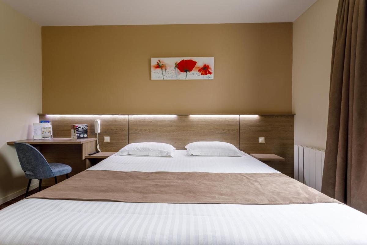 Un ou plusieurs lits dans un hébergement de l'établissement Brit Hotel Piscine & Spa - Fougères
