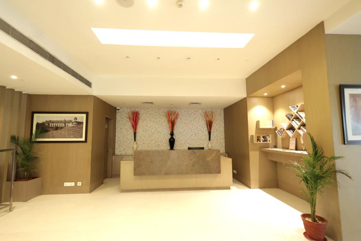 a lobby with a waiting room with vases on the wall at Ramada by Wyndham Lucknow Hotel and Convention Center in Lucknow