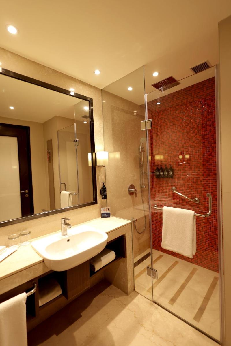 a bathroom with a sink and a shower at Ramada Plaza by Wyndham Lucknow in Lucknow