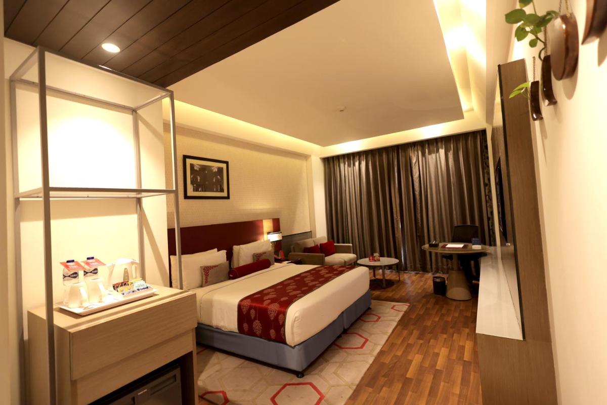 a hotel room with a bed and a desk at Ramada Plaza by Wyndham Lucknow in Lucknow
