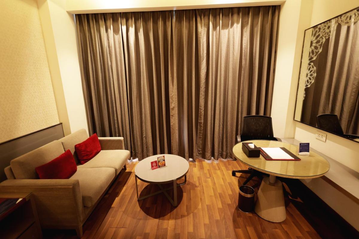 a living room with a couch and a table at Ramada Plaza by Wyndham Lucknow in Lucknow