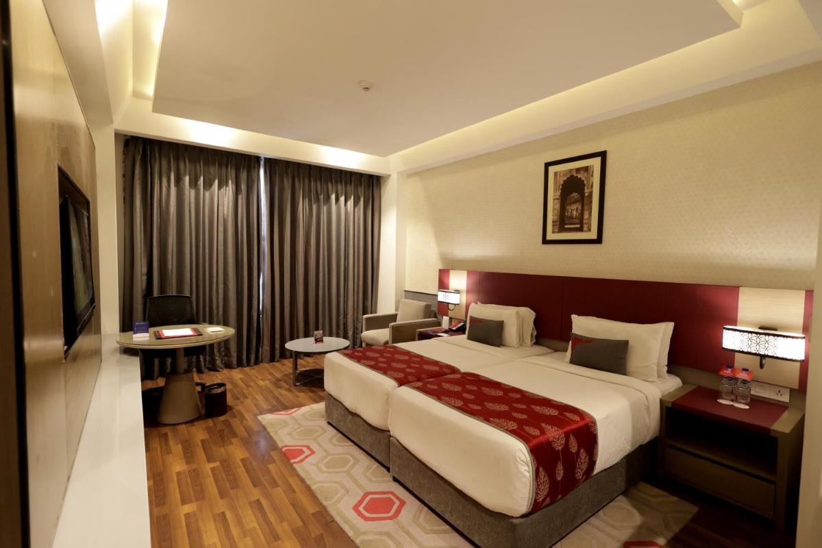 a hotel room with a large bed and a desk at Ramada Plaza by Wyndham Lucknow in Lucknow