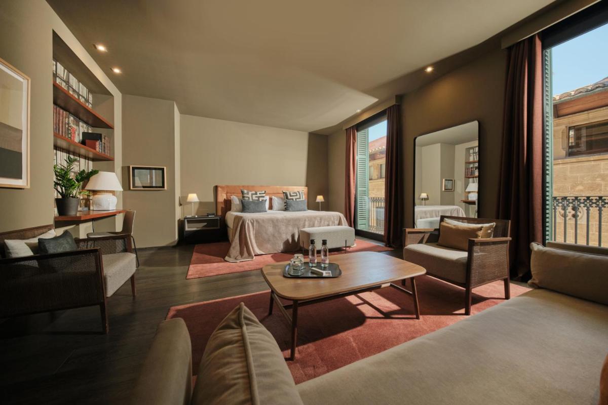 Una habitación de hotel con una cama y una sala de estar. en Hotel Can Alomar, en Palma de Mallorca