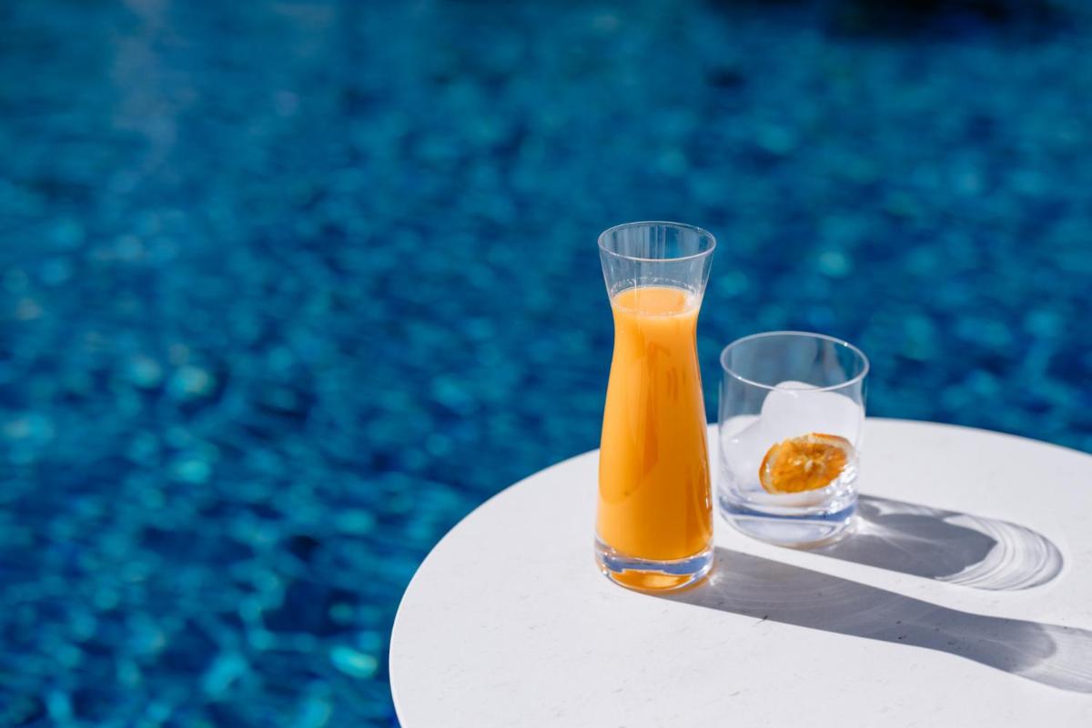 dos vasos de zumo de naranja sentados en una mesa en THE FLAG HOTEL Marbella, Estepona Adult Recommended, en Estepona