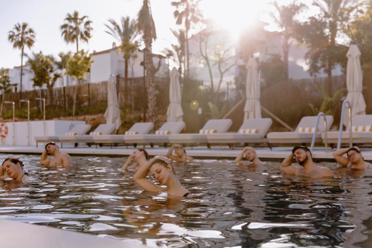 un grupo de personas nadando en una piscina en THE FLAG HOTEL Marbella, Estepona Adult Recommended, en Estepona