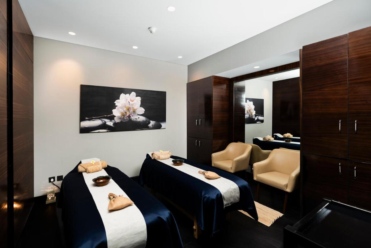 a hotel room with two beds and a mirror at Courtyard by Marriott Pune Hinjewadi in Pune