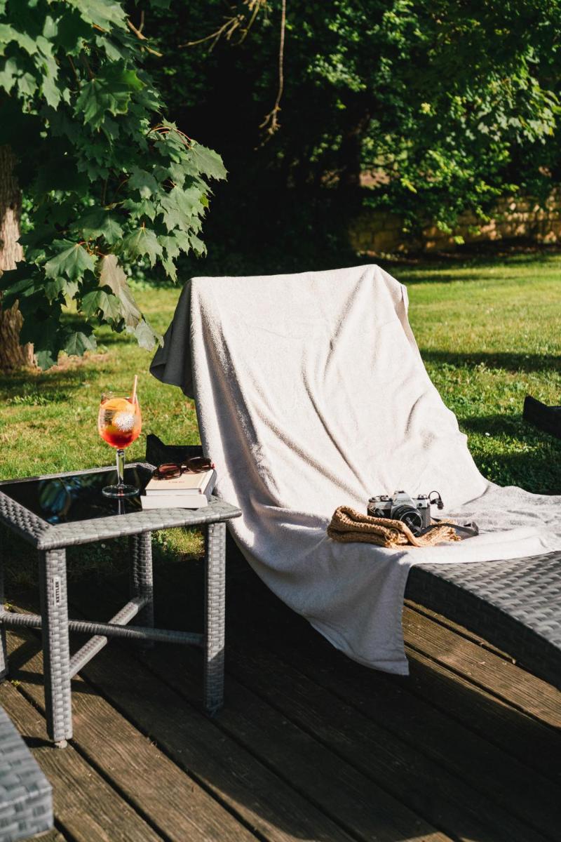 - une couverture sur un lit à côté d'une table dans l'établissement Chateau du Clos de la Ribaudiere - Teritoria, à Chasseneuil-du-Poitou 64 autres photos