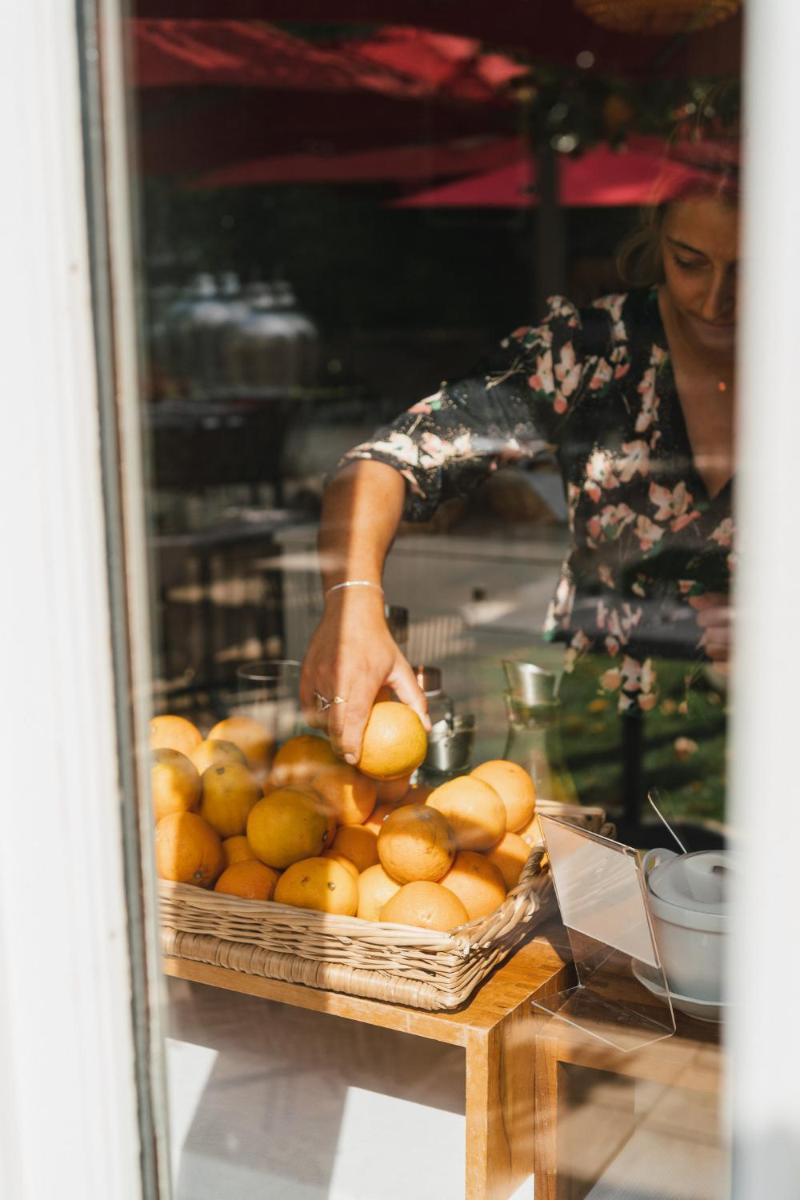 une femme debout derrière une table avec un panier d'oranges dans l'établissement Chateau du Clos de la Ribaudiere - Teritoria, à Chasseneuil-du-Poitou
